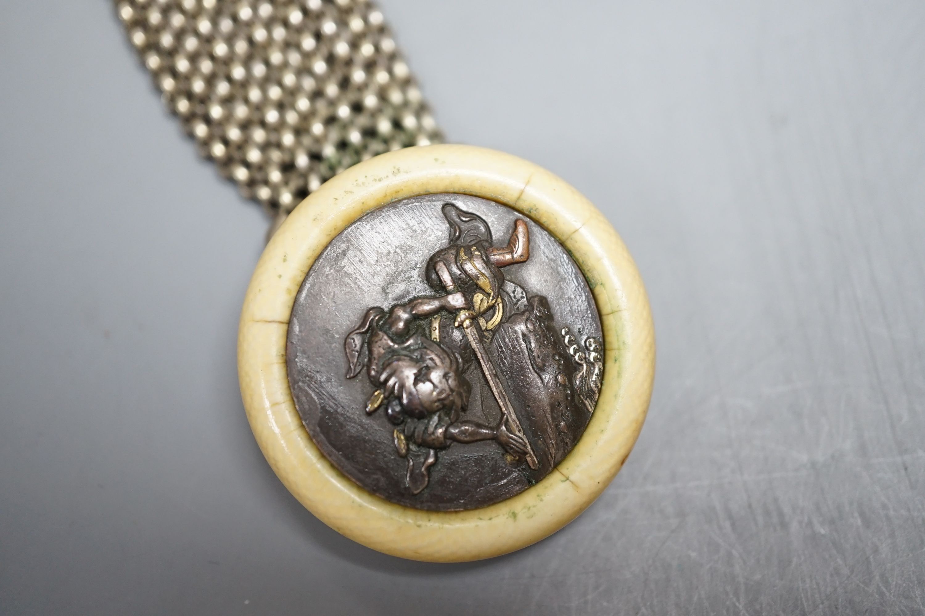 A Japanese ivory Manju netsuke with white metal and base metal suspension brooch